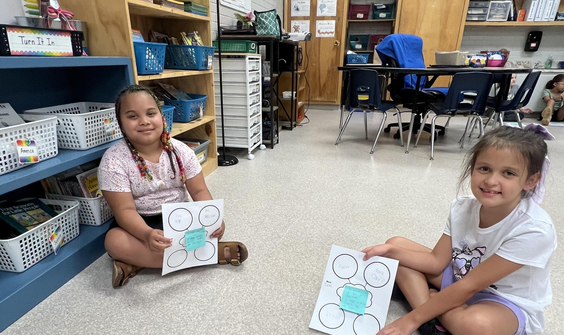 2 girls showing their work
