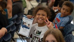 Image of student smiling while holding an award