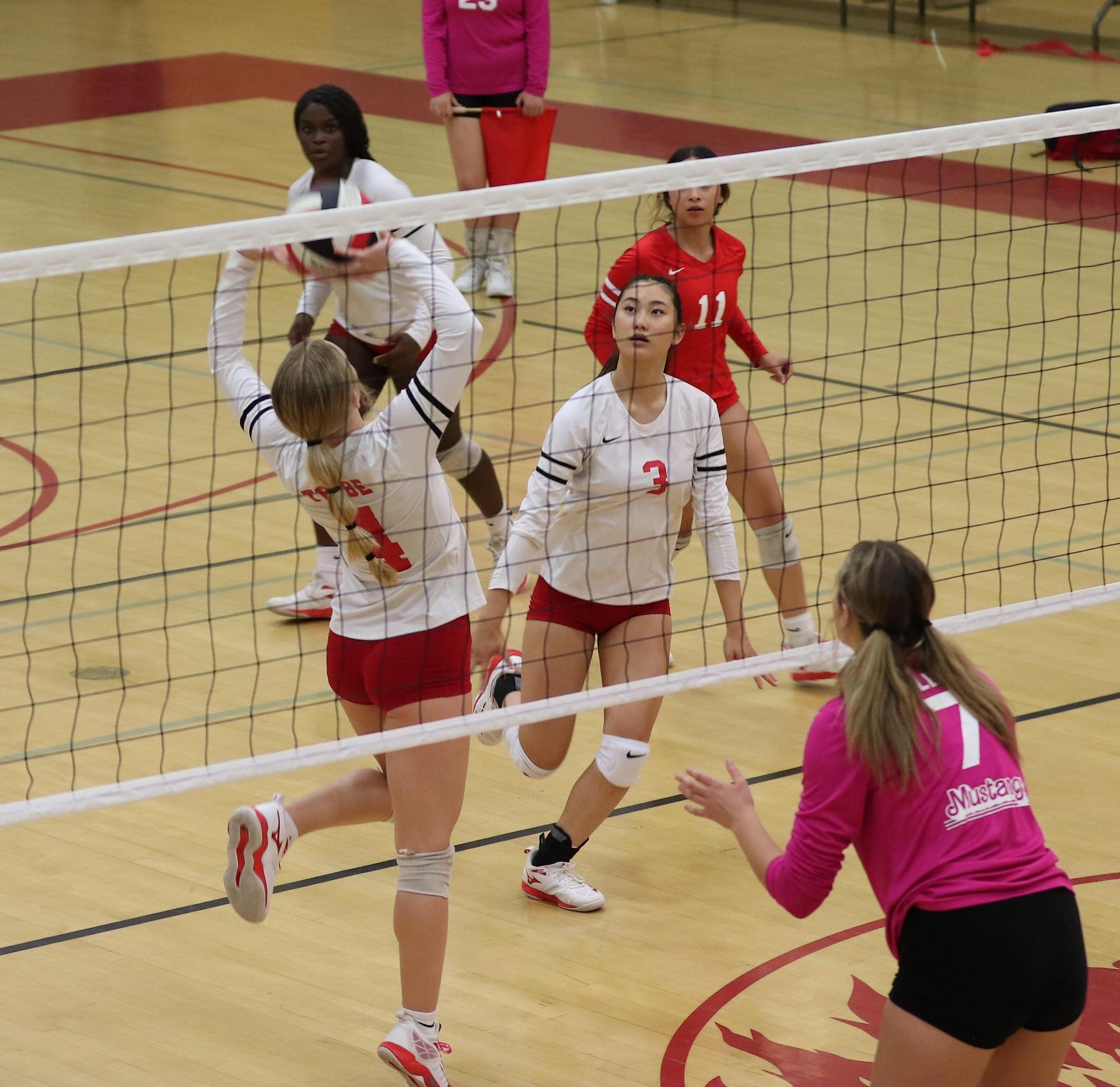 varsity volleyball players in action against Minarets