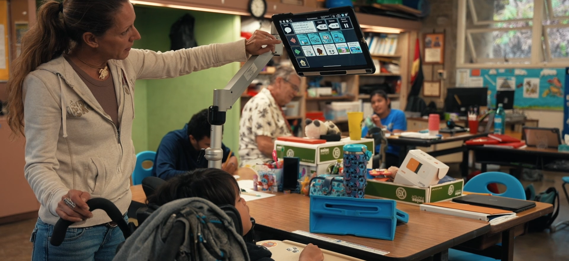 Special needs teacher pointing at monitor for student
