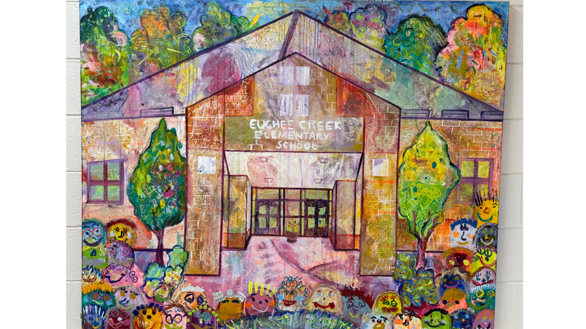 Colorful mural of Eugene Creek Elementary School surrounded by smiling, whimsical characters.