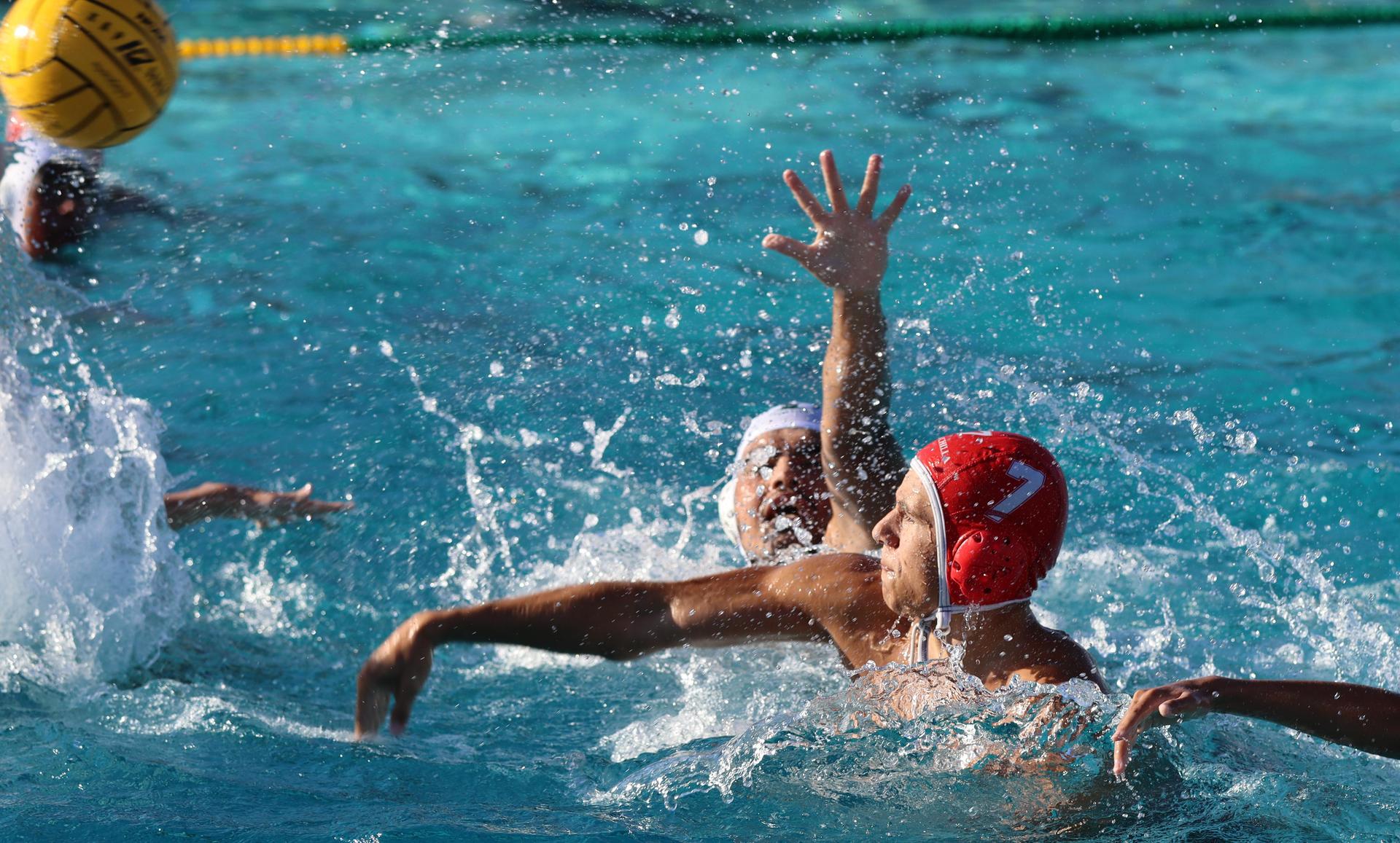boys water polo players in action against hoover