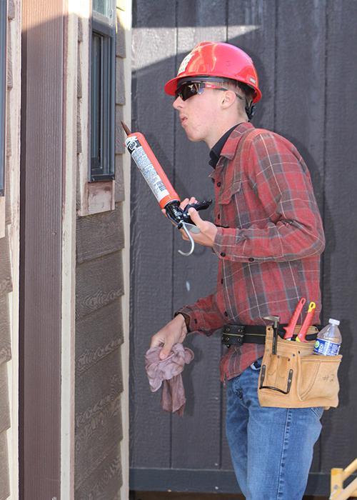 A student looks for the next place to caulk.