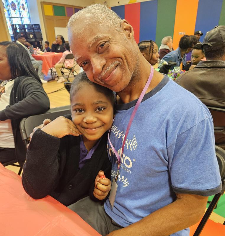 Image shows grandfather and granddaughter playing BINGO