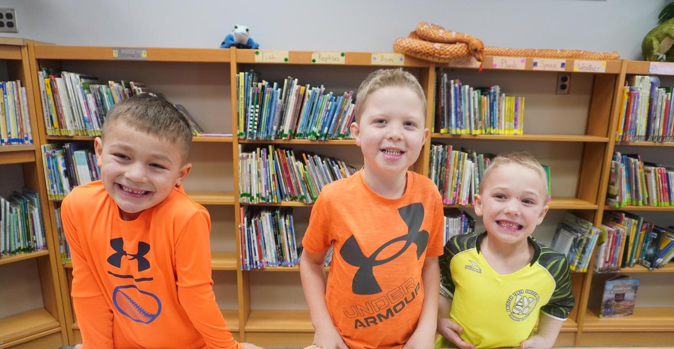 Three students wear brightly colored shirts as they let their kindness shine.