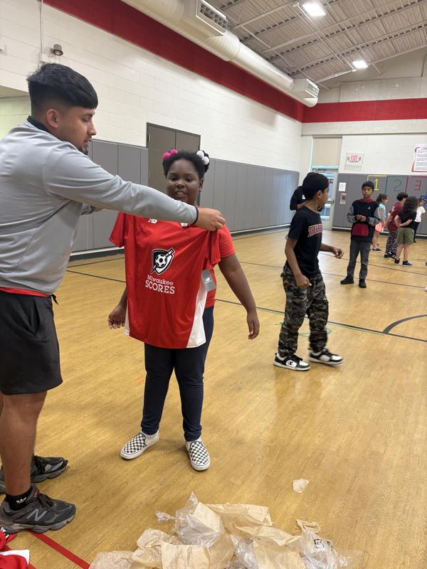A female student receives her SCORES jersey