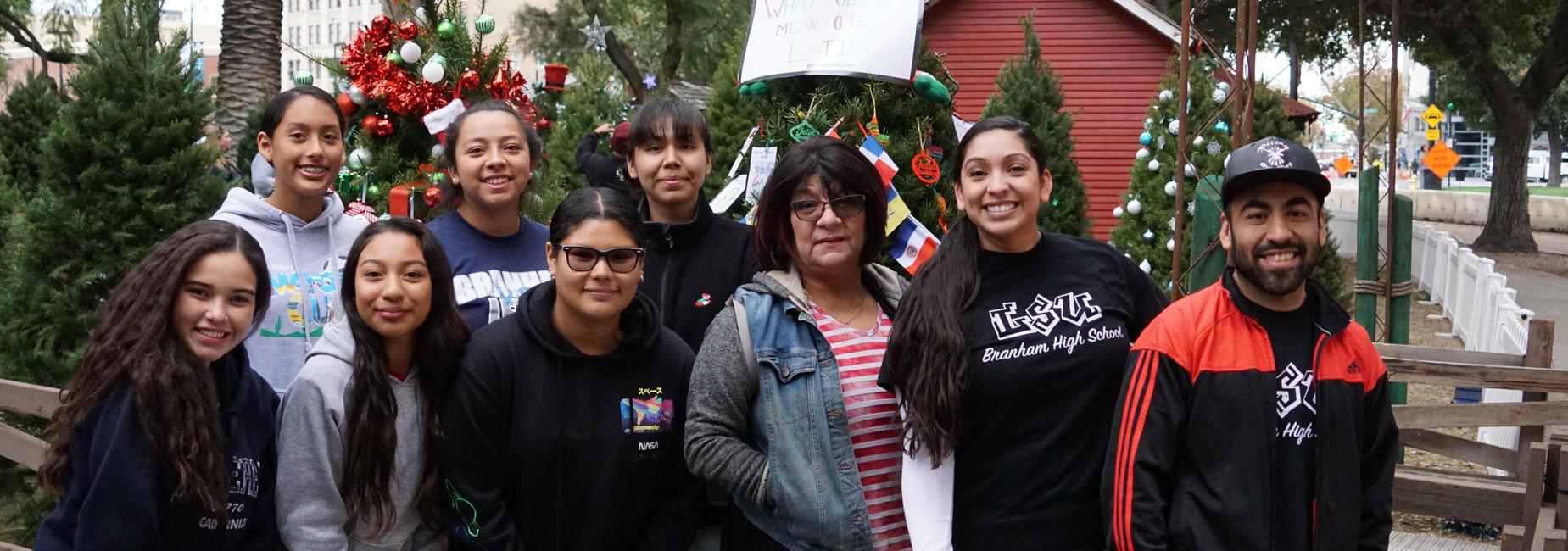 Students and teachers from LSU stand in front of their decorated Christmas tree.