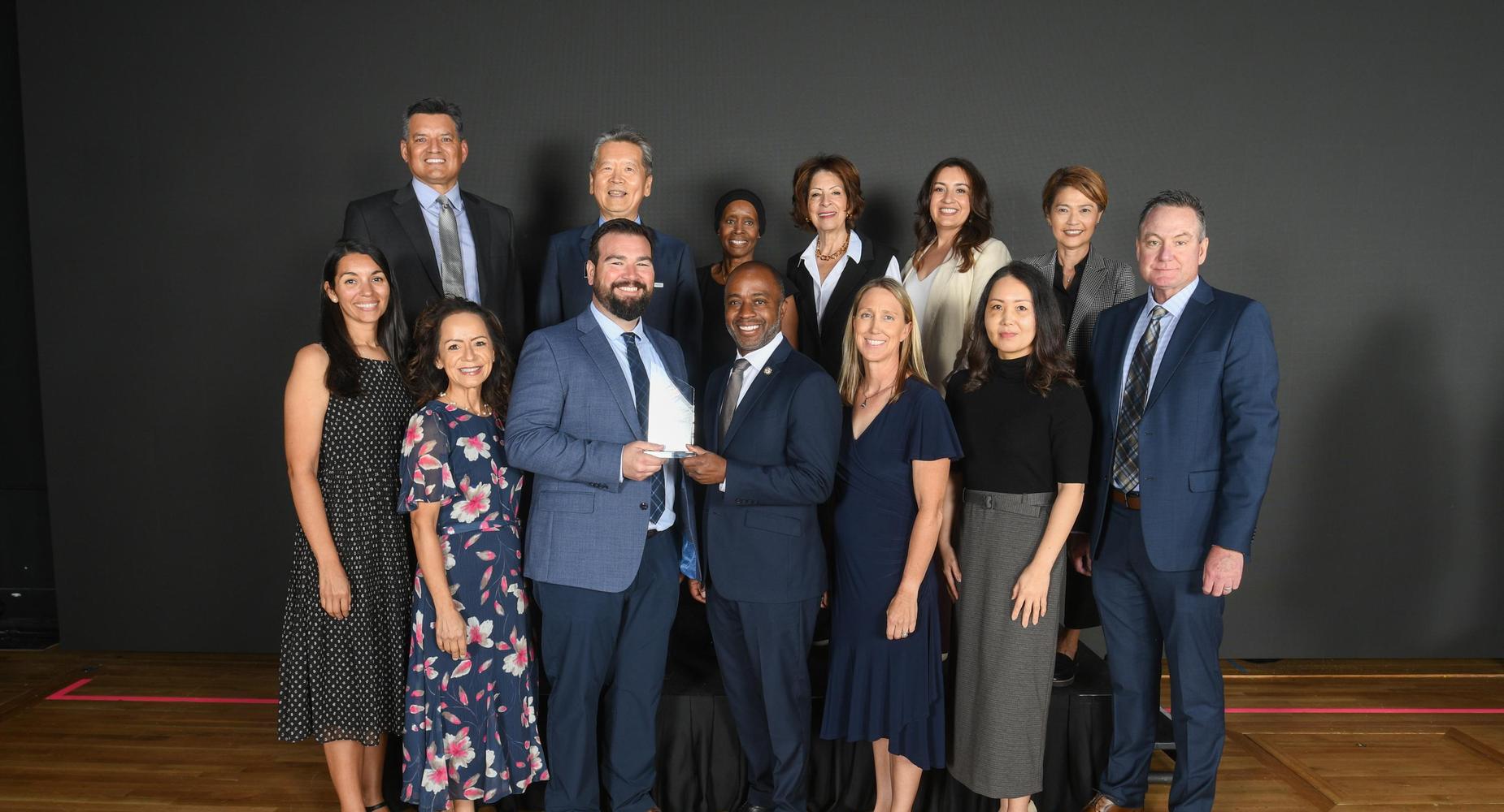 A diverse group of professionals posing together in a formal setting.