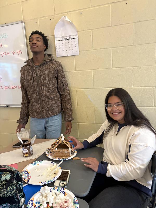 two students with gingerbread house