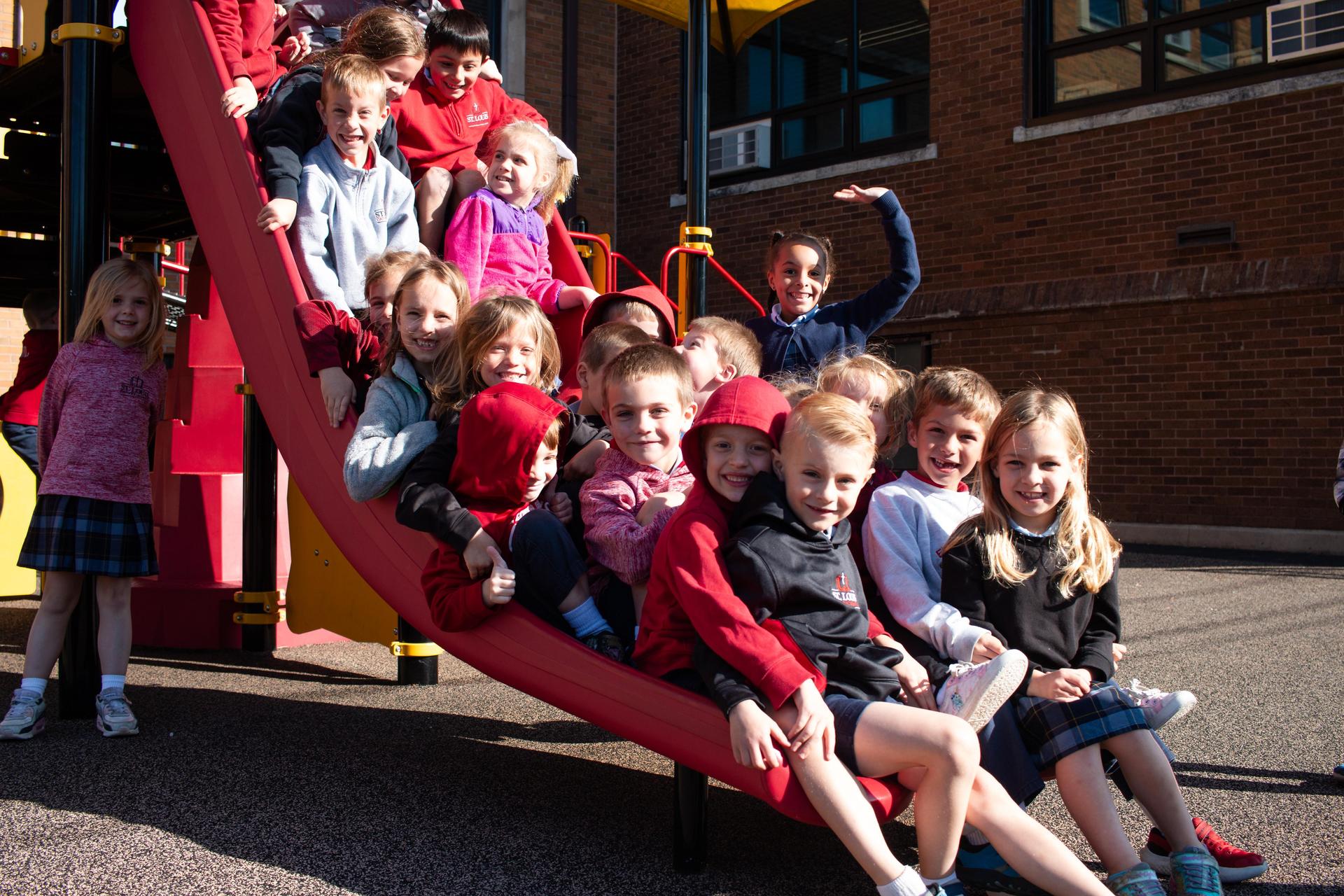 Several students sitting together on a slide.
