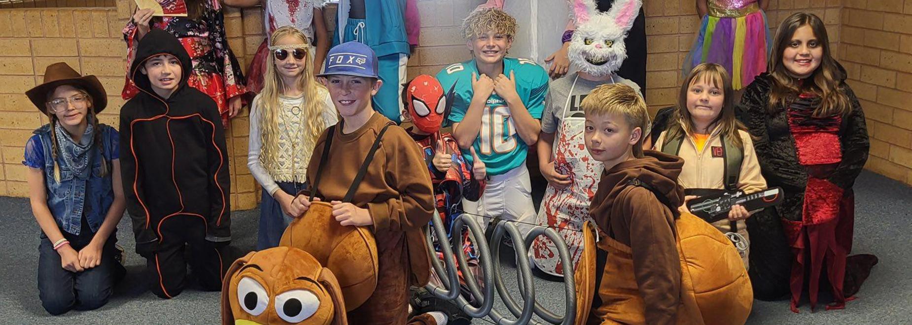 Students in various costumes posing together in a festive setting.