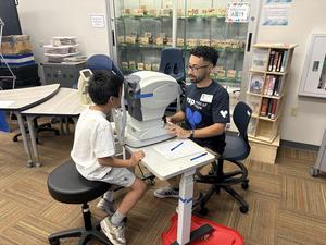 A student receives an eye exam