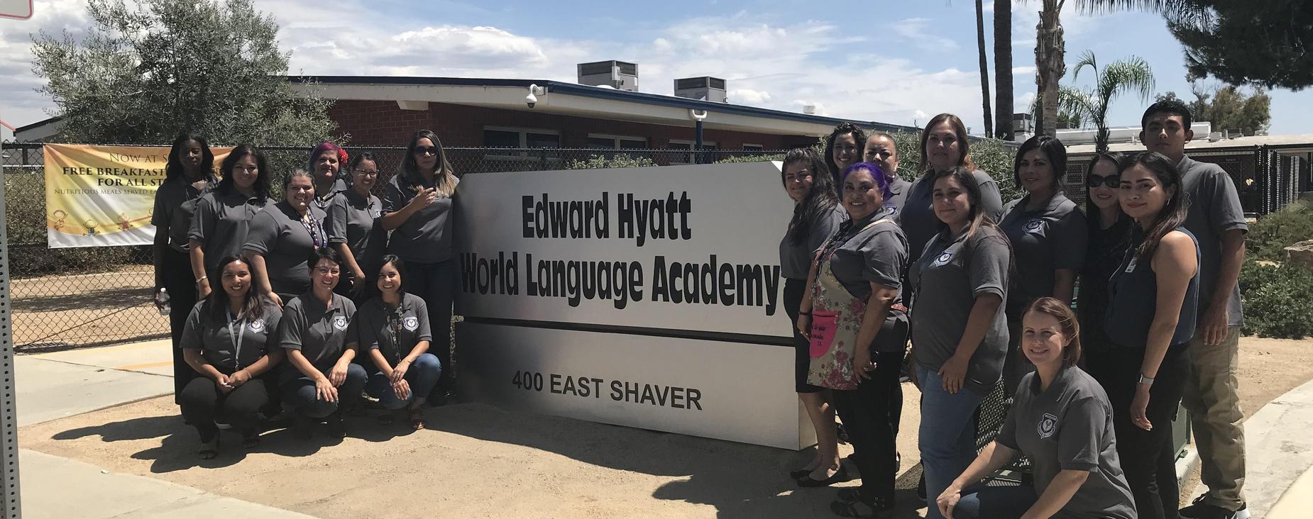 EHWLA Teacher's posing infront of their school name plaque