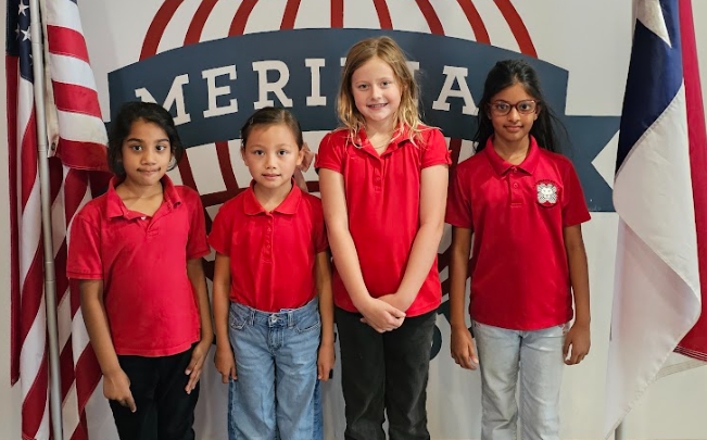 Students stand in front of the Meridian logo wall