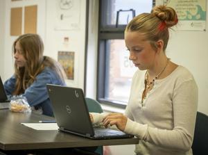 Female student typing on their laptop