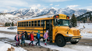 Young students boarding a school bus in a snowy landscape.