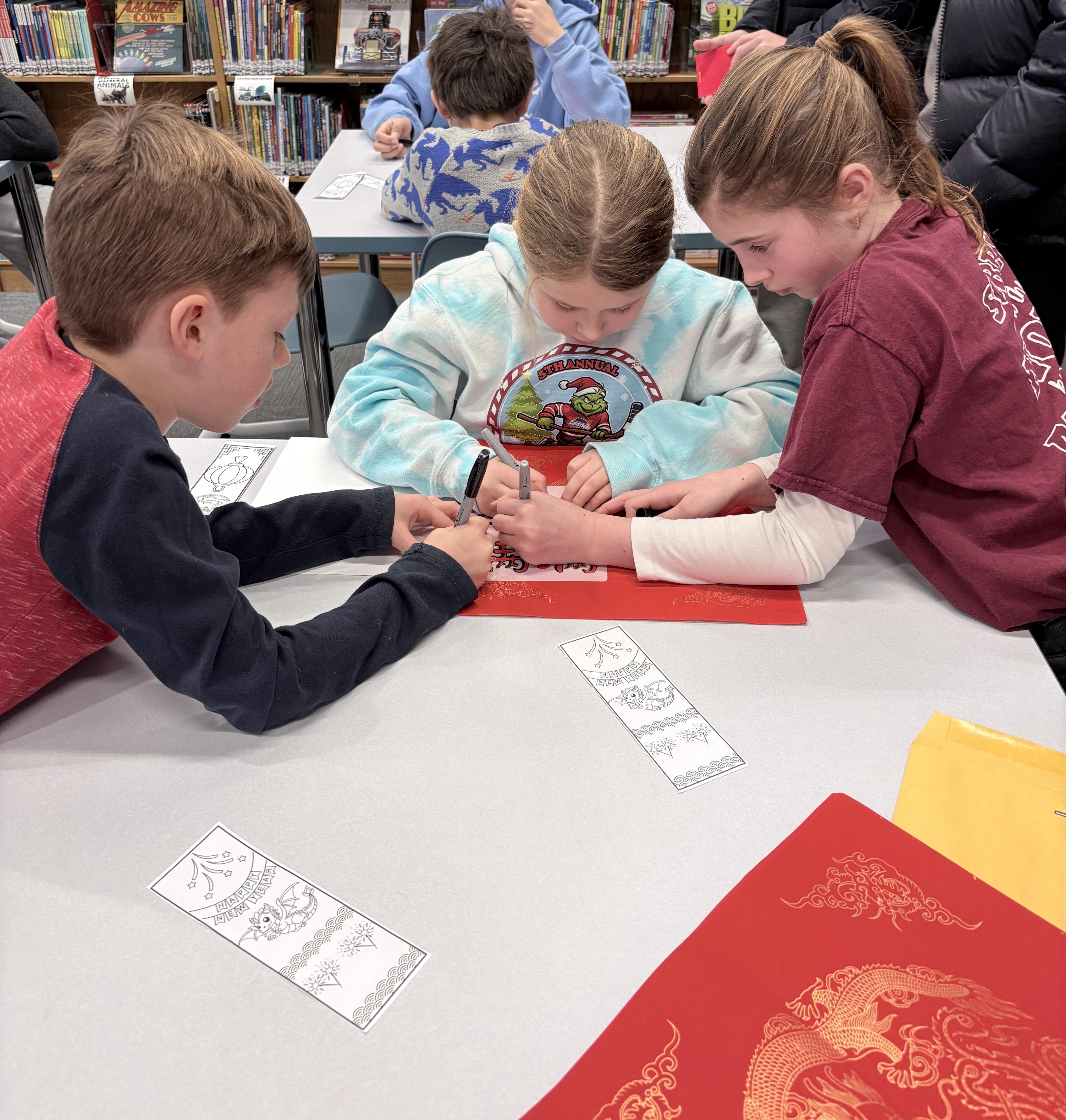 Three young students working on a Lunar New Year picture