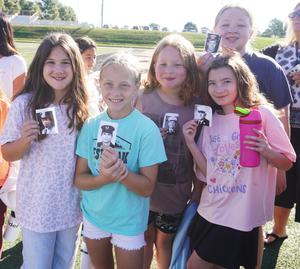 A group of students show photos they carried with them on their 9-11 stair challenge.