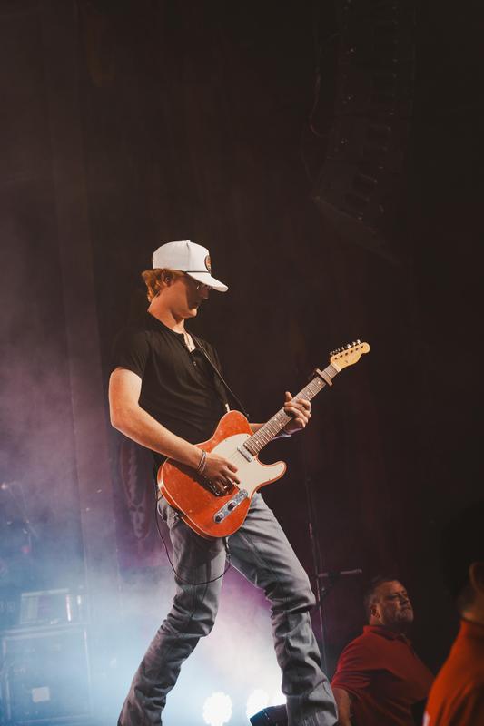 gage mcneely playing guitar during a concert