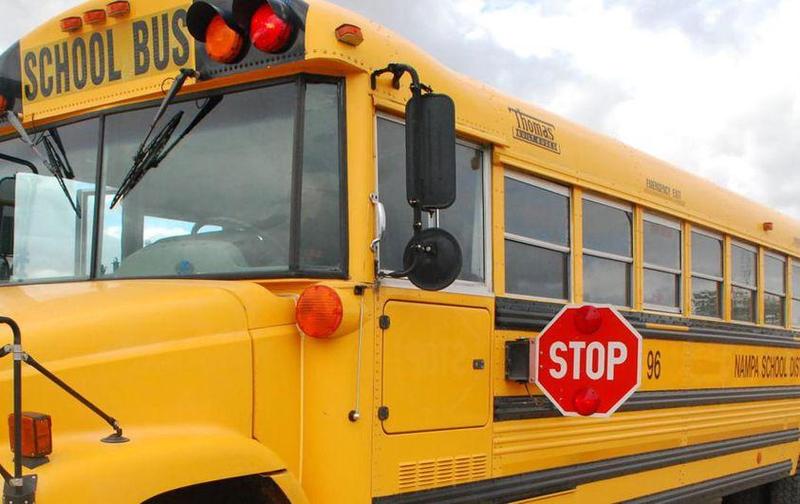 Long view of driver's side of yellow school bus.