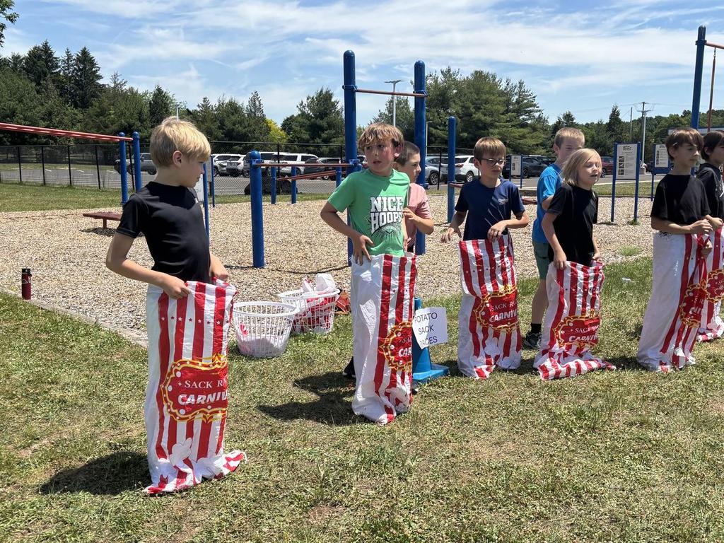 Elementary students in a sack race on the playground.