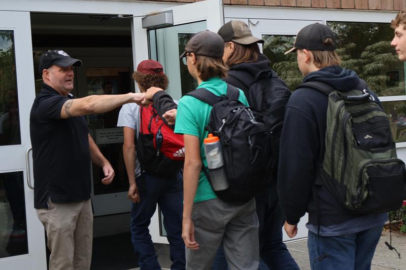 Counselor Michael Bombardier give arriving freshman fist bumps