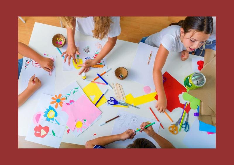 overhead photo of 4 kids coloring at a table