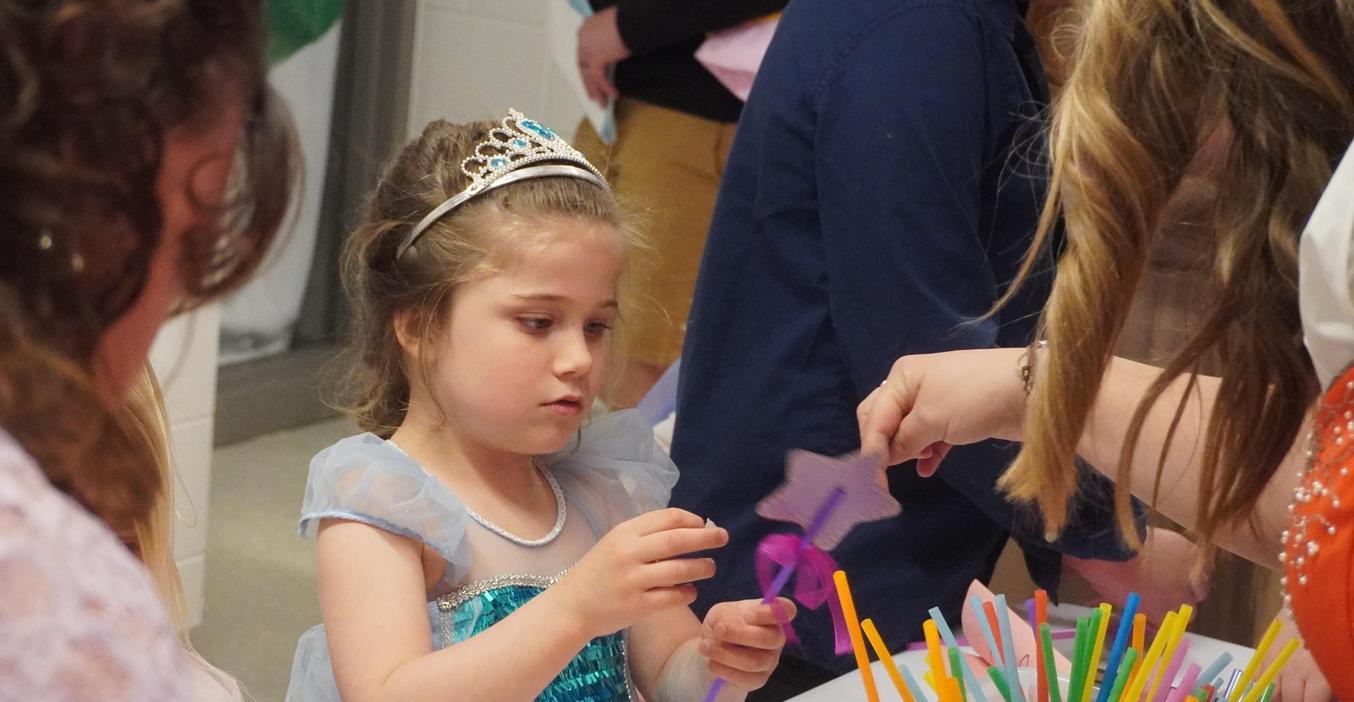 A student gets a little help making a magic wand at the literacy ball.