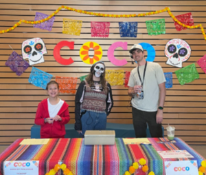 Three people standing at the ticket table for Coco