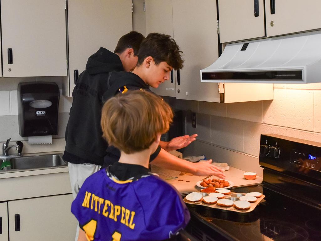 Three students baking in one of the Exploratories classrooms.