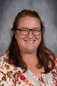 Female teacher with long hair and glasses