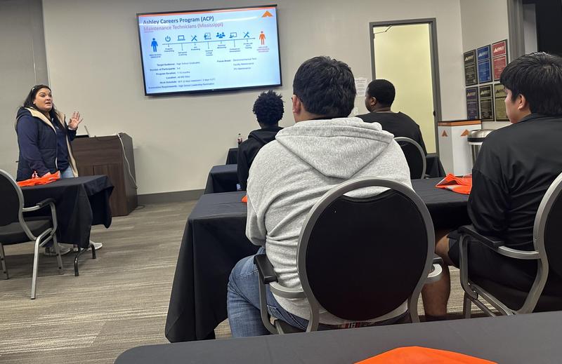 Students sitting in desks listening to speaker