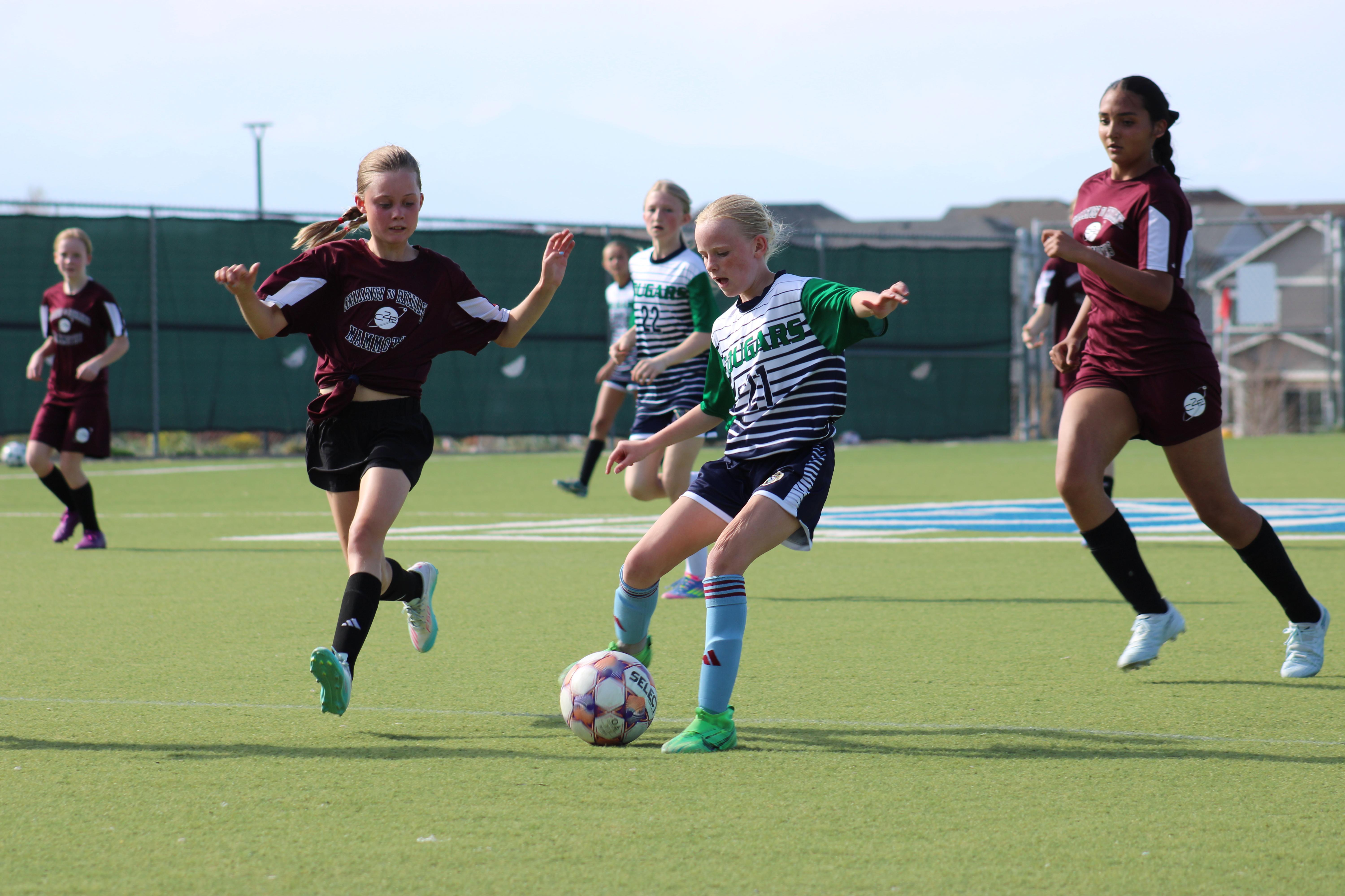 Girls soccer player kicks ball