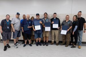 The facilities team poses with their certificates