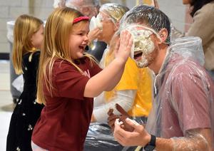 a student tossing a pie into a teacher's face