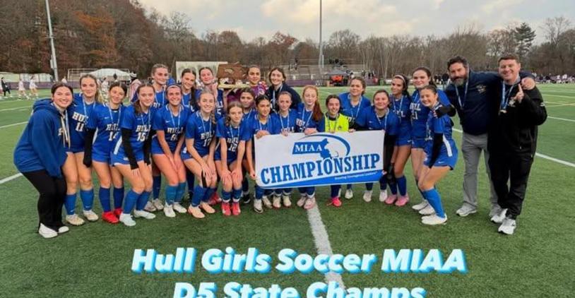 Hull Girls Soccer team celebrating their D5 State Championship win with a banner.