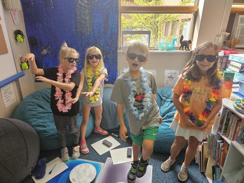 Second-graders Cassandra Hall, Leah Haendler, Adrian Zdrale, and Francesca Petrini use the Hawaiian-themed materials during a lesson