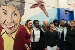 APRCHS' founding Principal, Dr. Lottie Taylor, posing with current students who designed and painted the mural outside the Lottie Taylor Library dedicated in December 6th, 2016