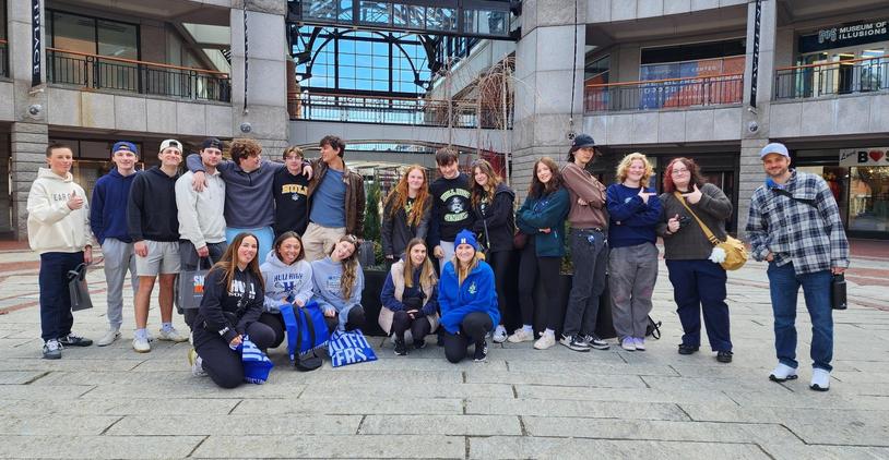 Group of students posing for a photo indoors with a decorative fountain in the background.