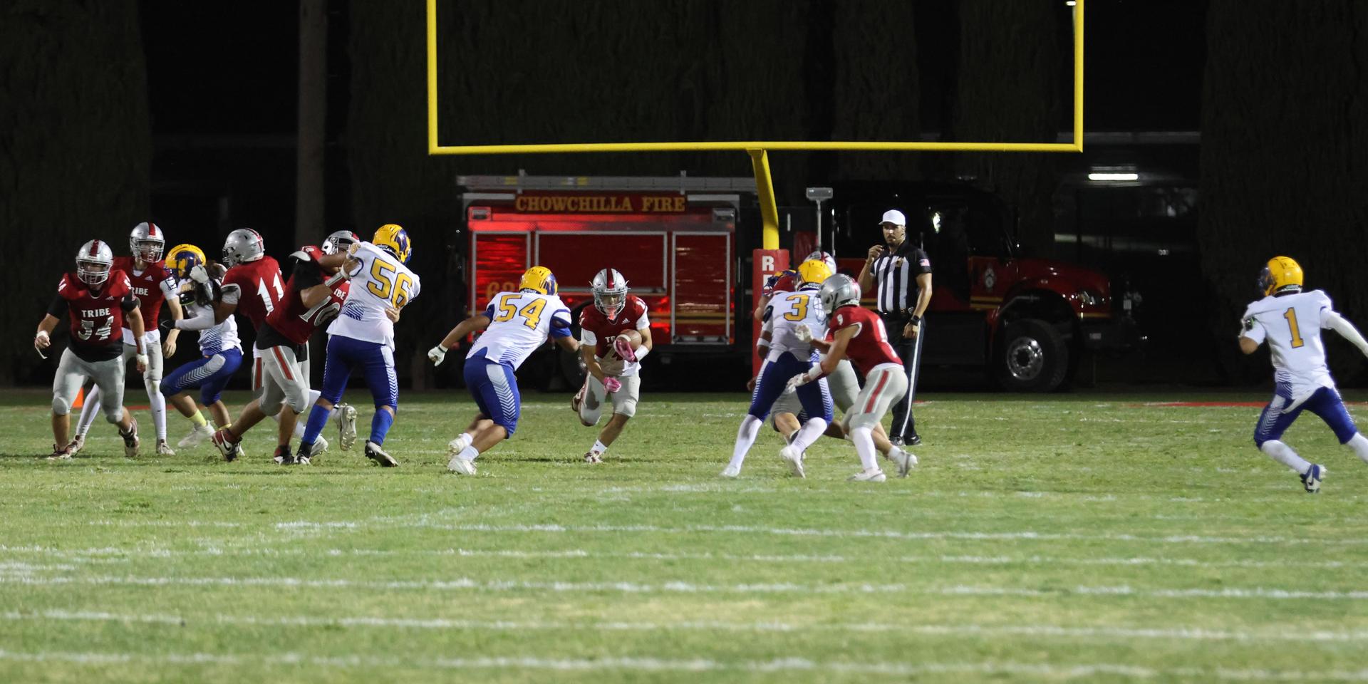 Varsity football players in action against Parlier 19