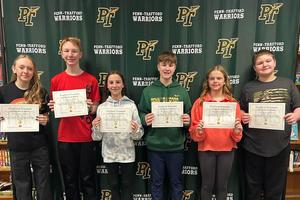 Trafford Triumphs honorees stand with their certificates in front of a Penn-Trafford backdrop