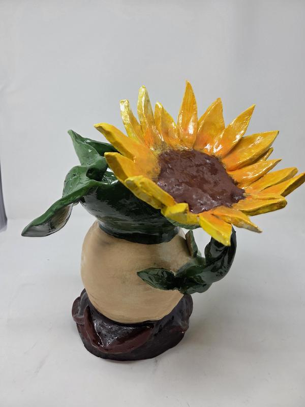 Clay fired artwork of a coffee mug with a sunflower in it.
