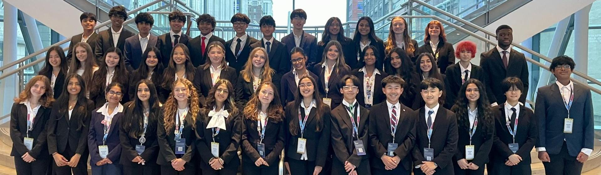 HOSA - A large group of young people dressed in formal attire, posing together on stairs at the HOSA International Conference.