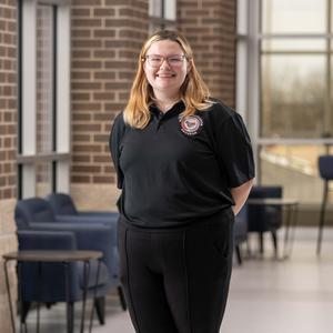 student standing with hands behind back