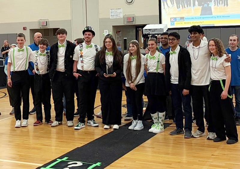 a group of students wearing white shirts and black pants