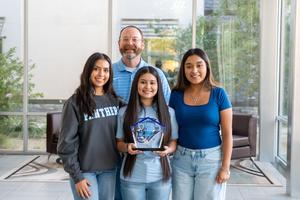 Group photo of the Memorial students holding the award.