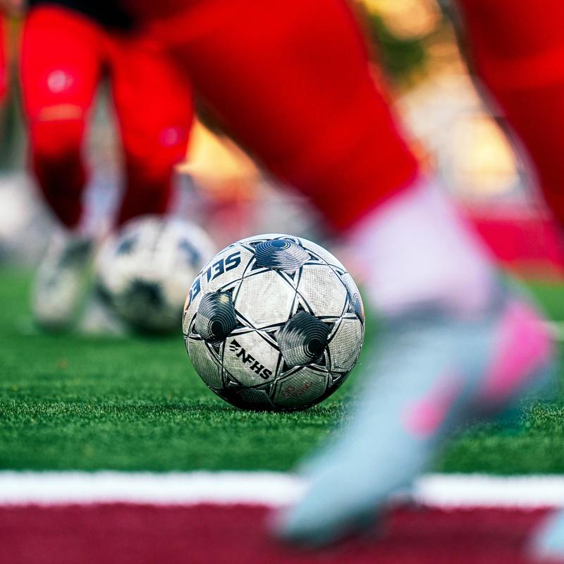 A close up of a soccer ball on green turf