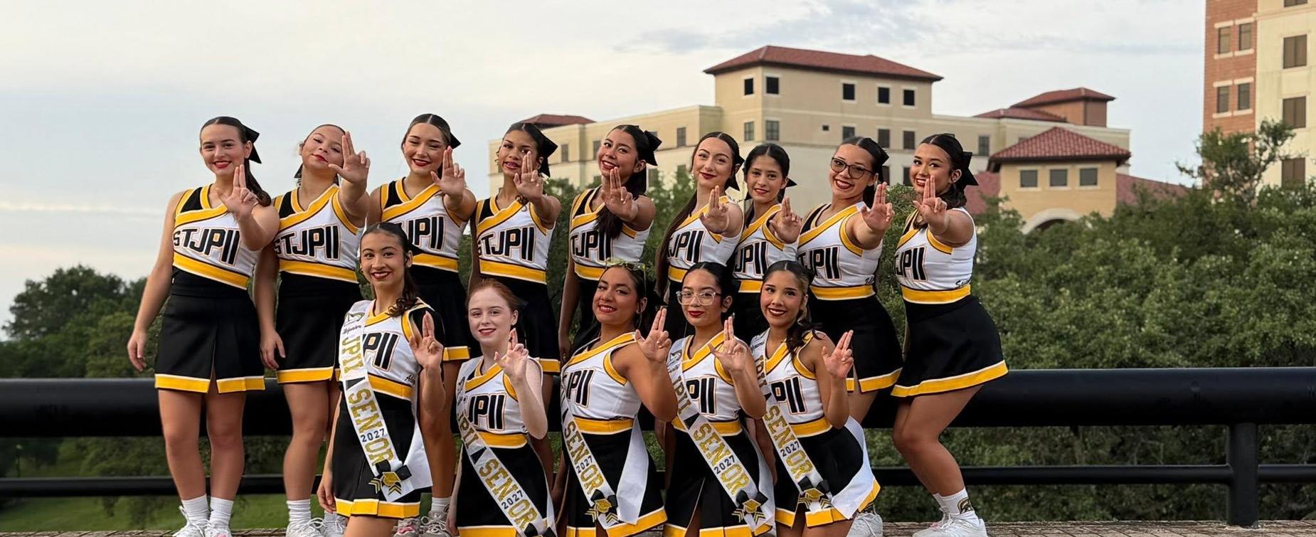 A group of cheerleaders posing together outdoors, all wearing uniforms.