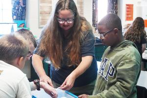 Dana Strouse with the Michigan Department of Great Lakes and Energy helps students identify insects.