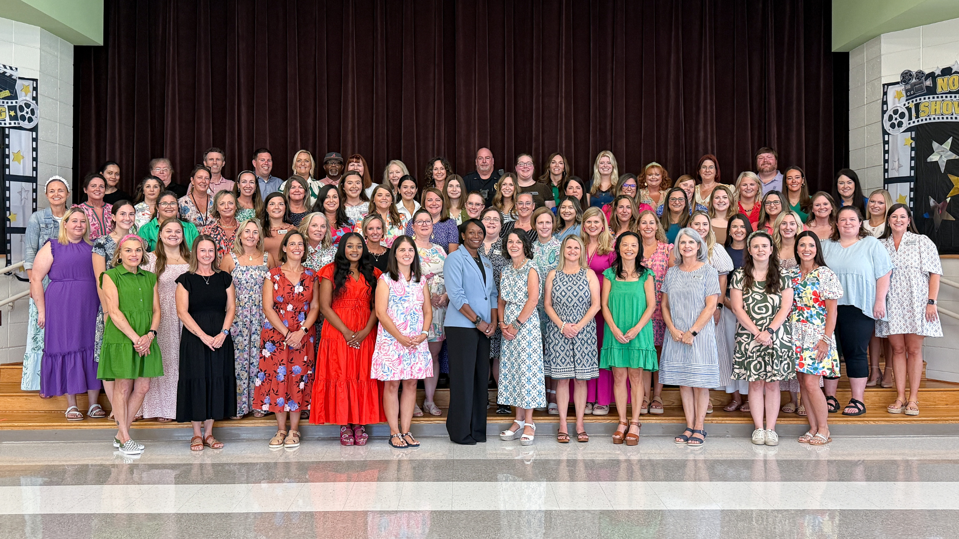Large group photo of teachers and staff standing together at a school event.